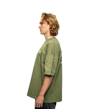 Person wearing a green oversized t-shirt on a white background