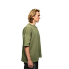 Person wearing a green oversized t-shirt on a white background