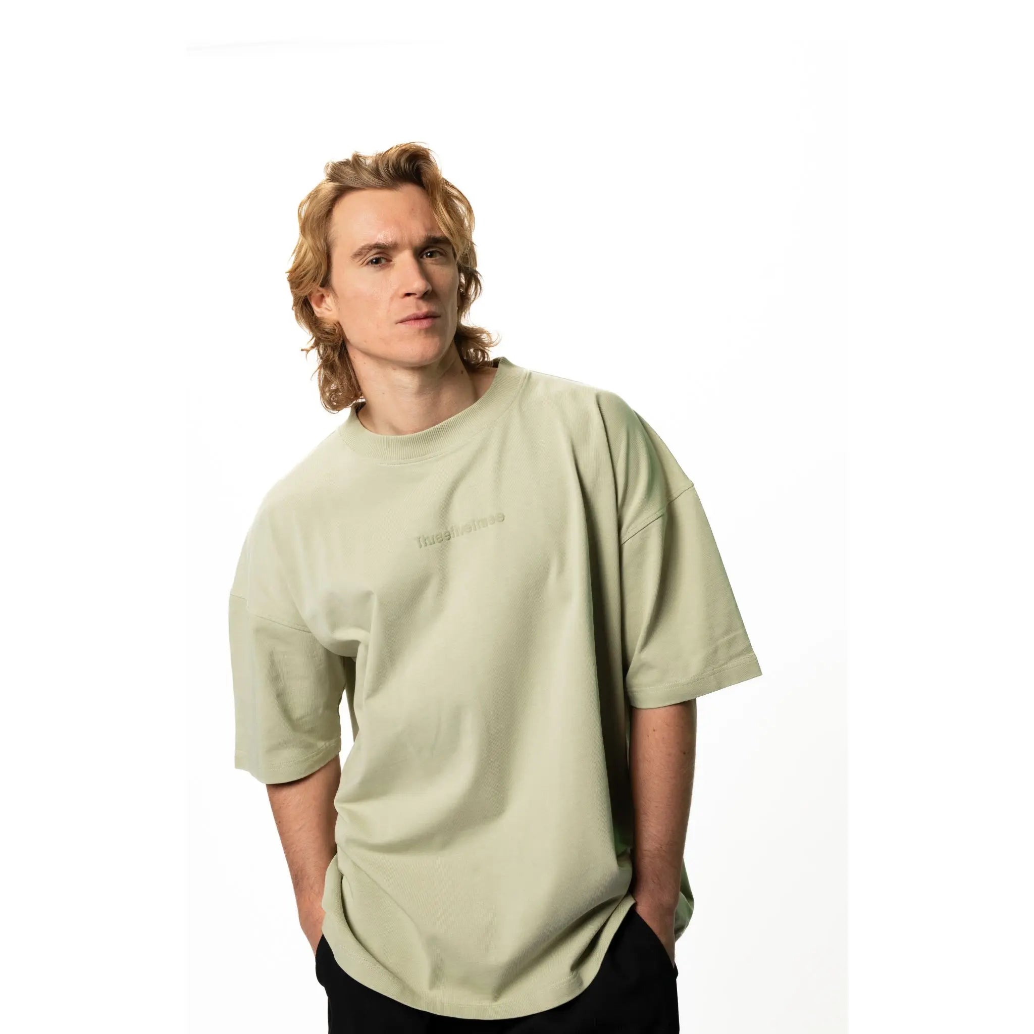Person wearing a light green t-shirt on a white background
