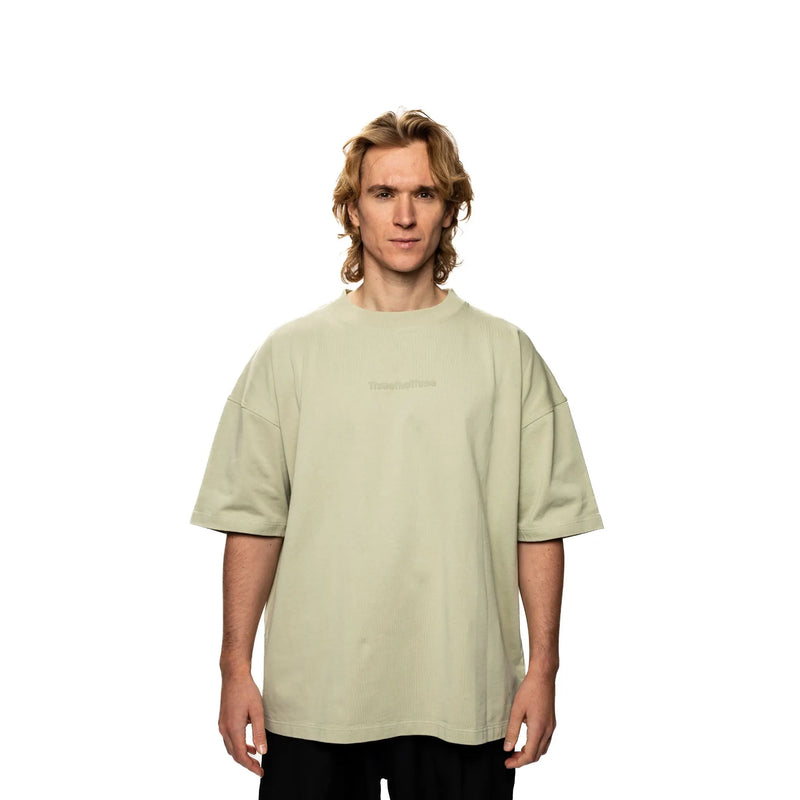 Man wearing a light green t-shirt with text on a white background