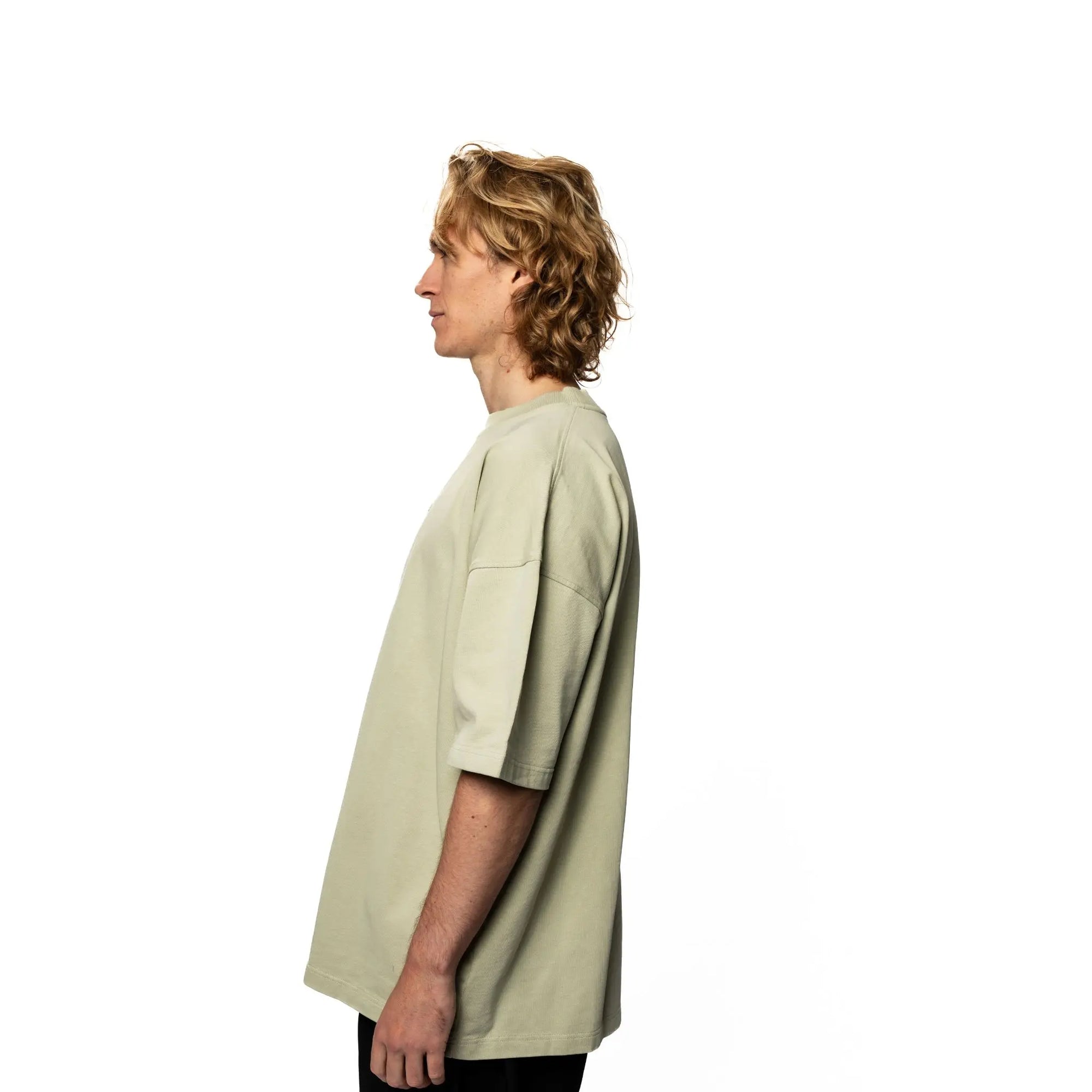Person wearing a light green oversized shirt on a white background