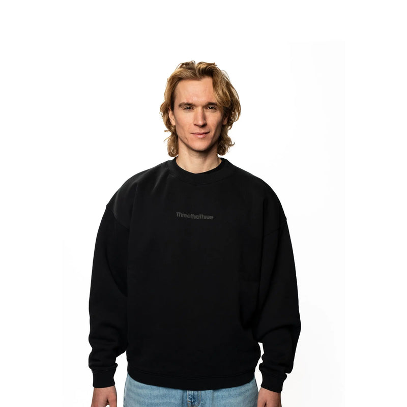 Person wearing a black sweatshirt with text on a white background