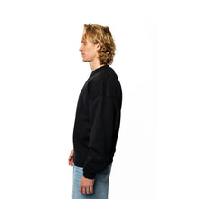 Person wearing a black sweatshirt and blue jeans on a white background