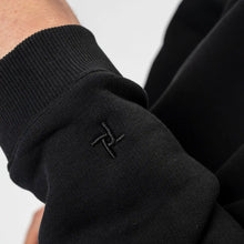 Close-up of a black sleeve with a logo on a white background